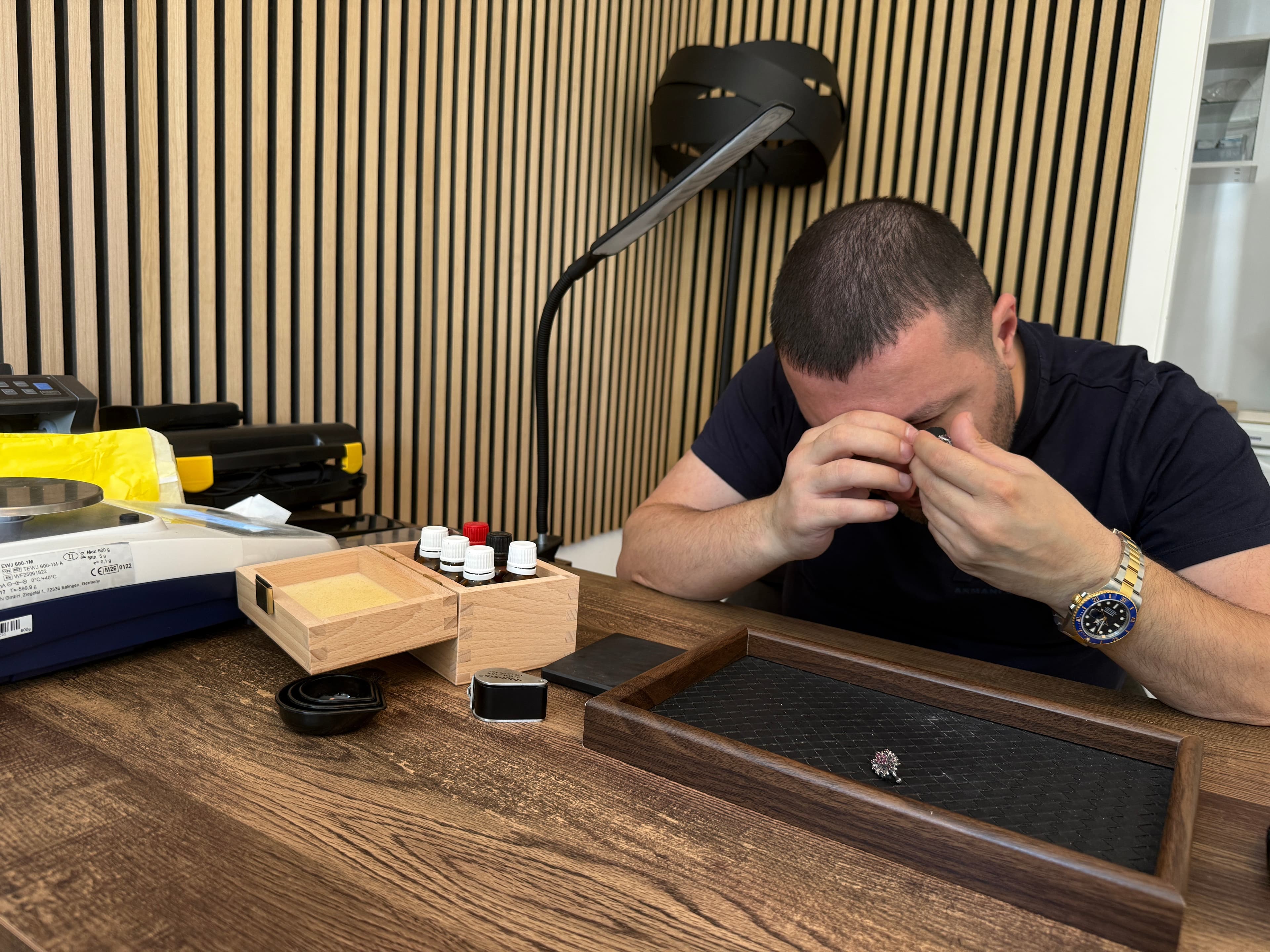 Goldexperte prüft Schmuck mit Lupe